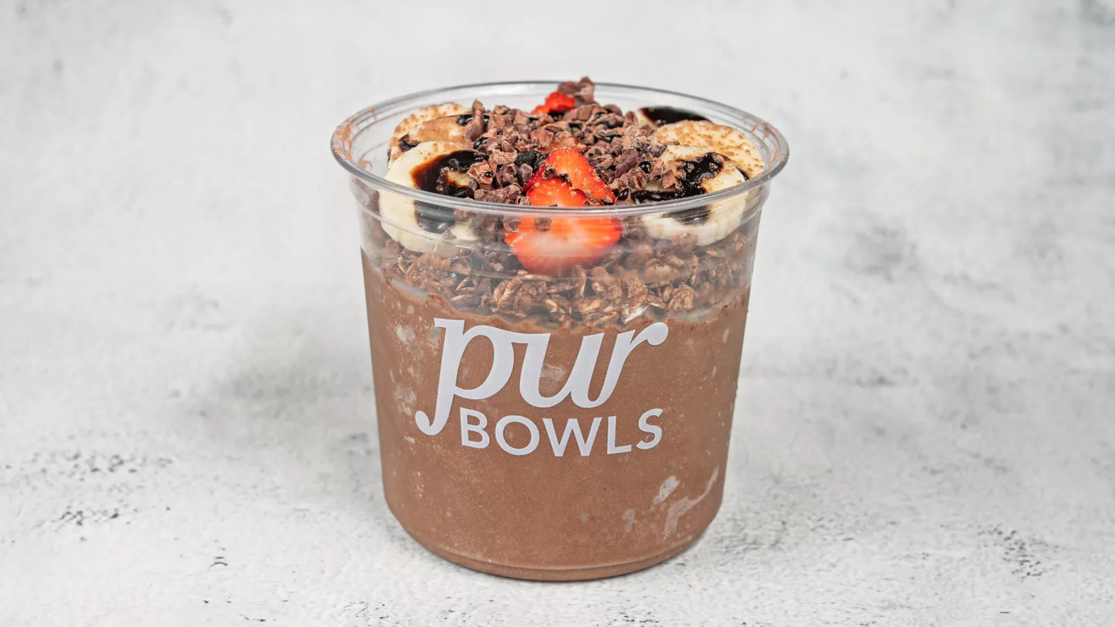 Cacao Bowl topped with banana, strawberries, granola, and cacao