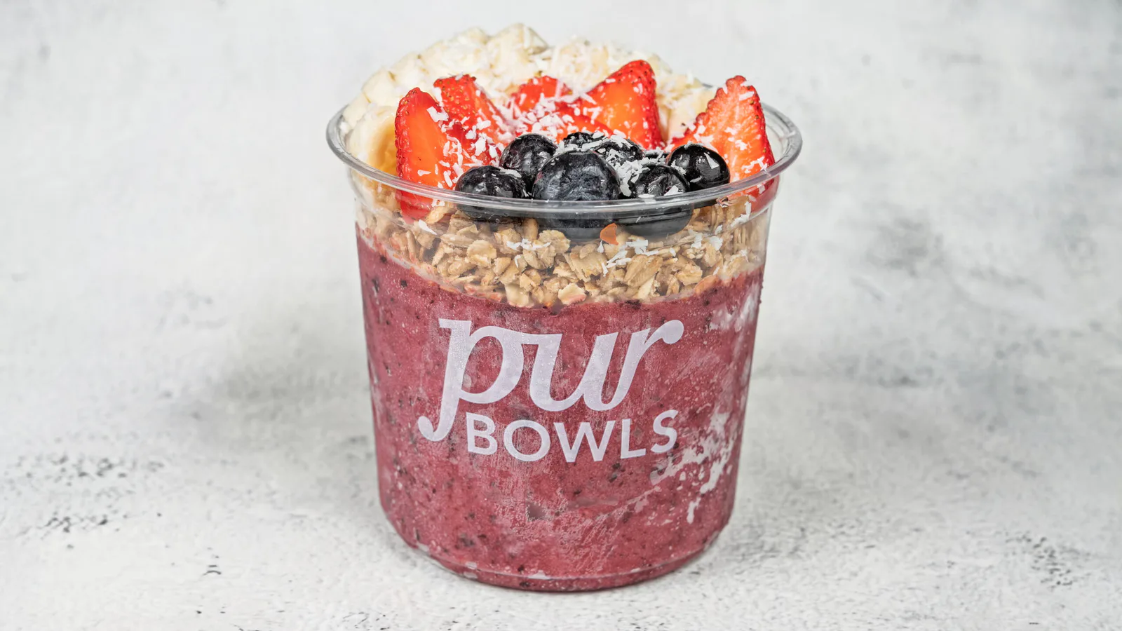 Very Berry Bowl with mixed berry base, banana, strawberries, blueberries, granola, and coconut